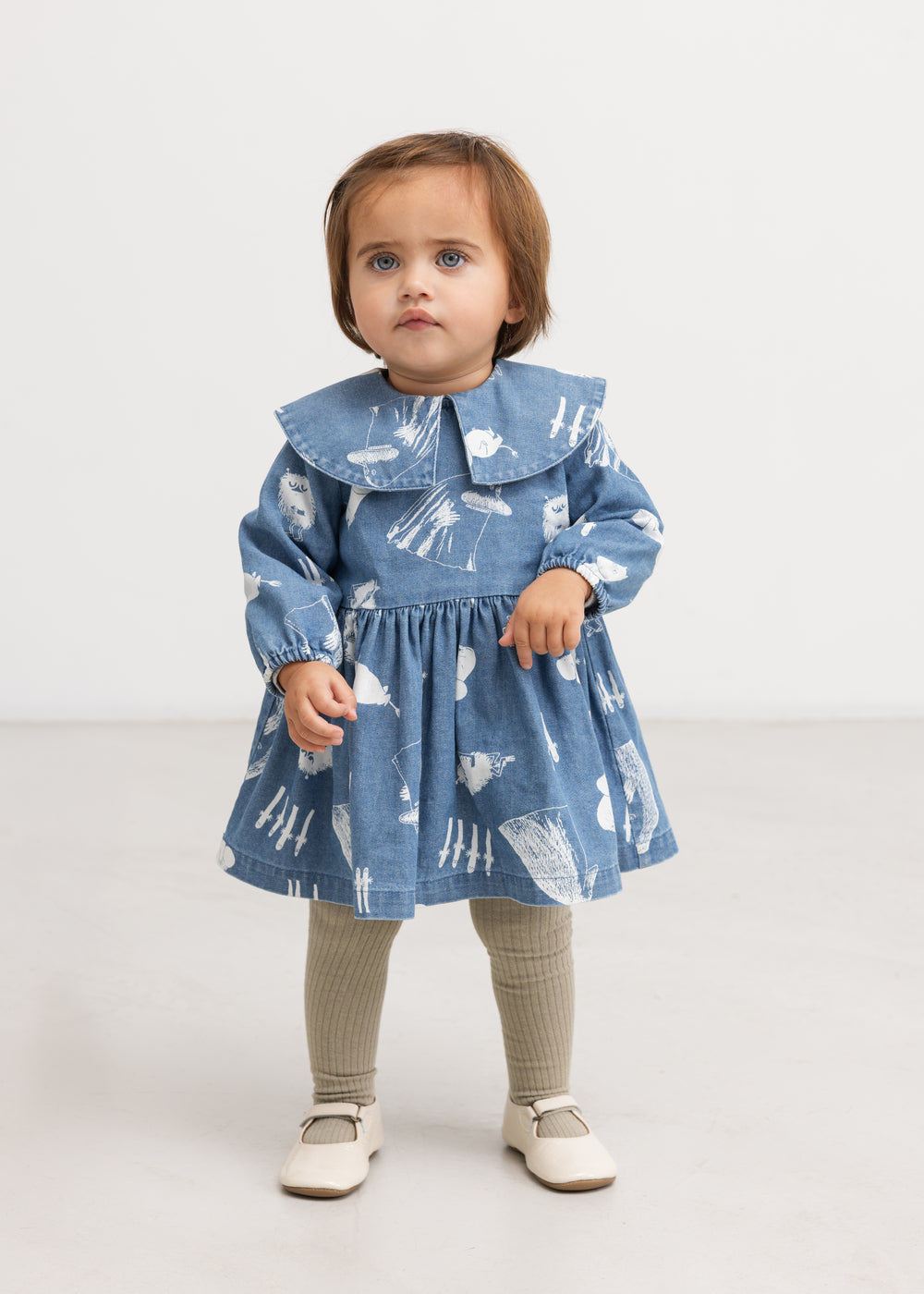 Blå denimkjole med Moomins-mønster, rund krave og rynket skørt på model