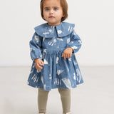 Blå denimkjole med Moomins-mønster, rund krave og rynket skørt på model
