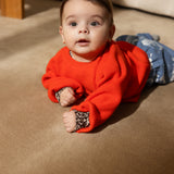 Torin B orange strikbluse på baby, rund hals og ribkanter ved ærmer