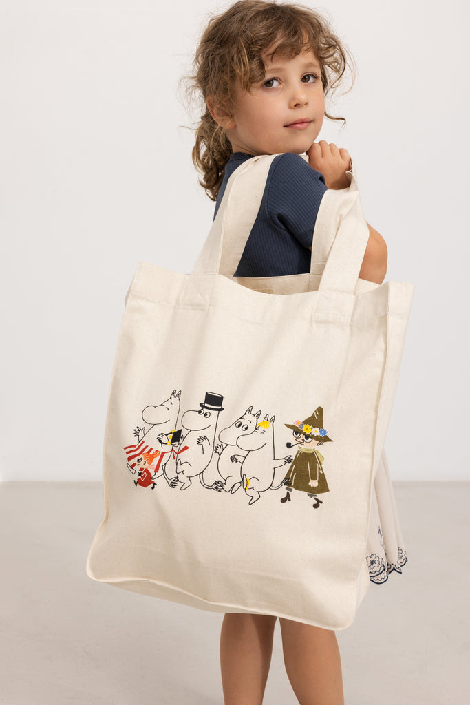 Creme shopper-taske med Moomin-figurer i forsideprint, bærehåndtag øverst