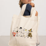 Creme shopper-taske med Moomin-figurer i forsideprint, bærehåndtag øverst