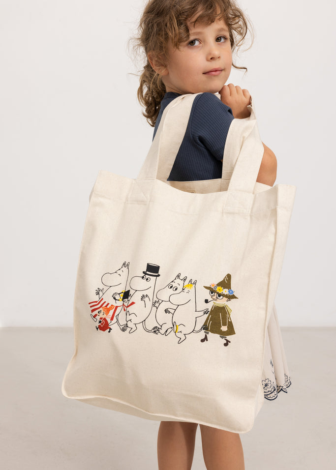 Creme shopper-taske med Moomin-figurer i forsideprint, bærehåndtag øverst