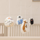 Babymobil med fire Moomin-figurer i stof, ophængt fra rund ramme.