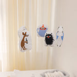 Babymobil til baby med flere Moomin-figurer, ophængt i små stofposer.