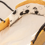 Foldebar stofbogs indre side med Moomin-illustrationer og snørebånd i hjørnet