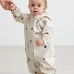 Baby iført beige regndragt med Moomin print og hætte