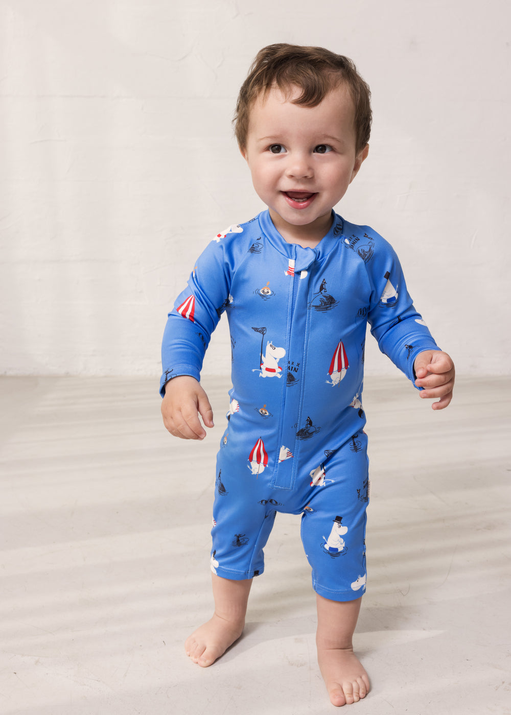 Blå badeheldragt til baby med lynlås foran og sødt Moomin-mønster
