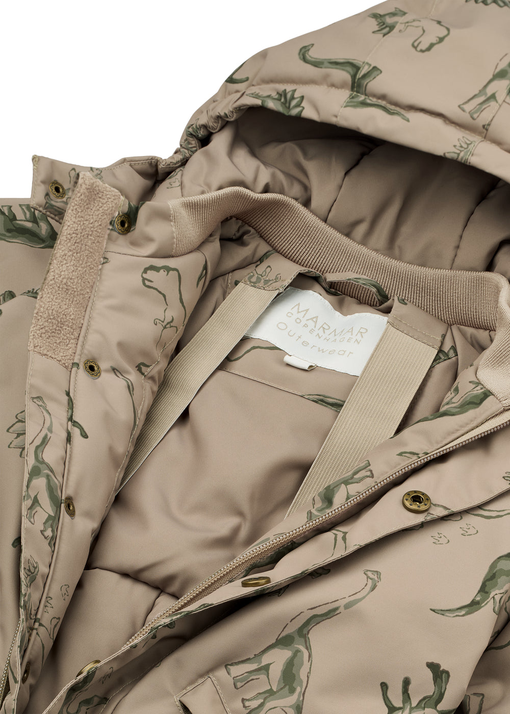 Detalje af beige flyverdragt med dinosaurprint, lynlås, trykknapper og indvendig foer