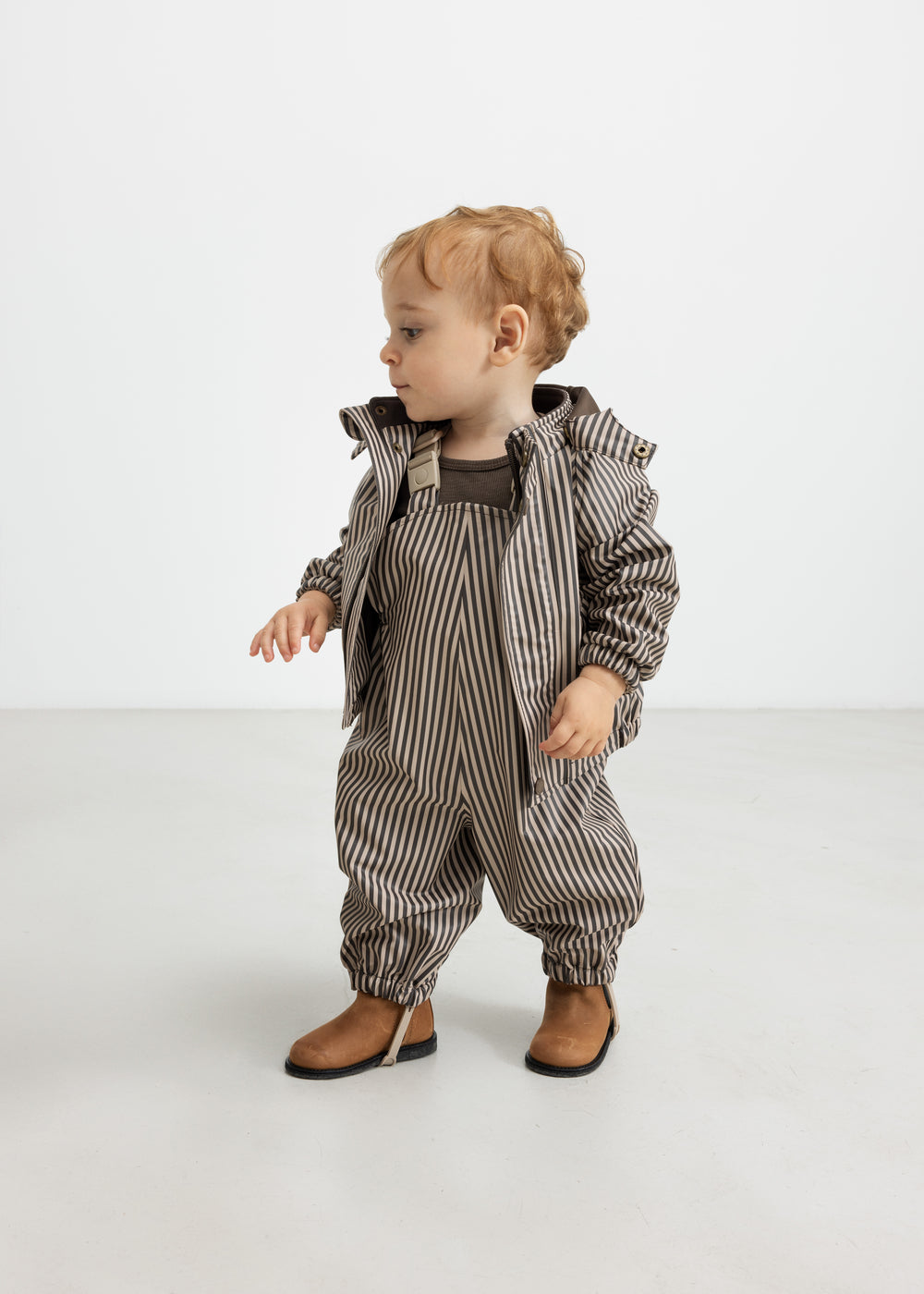 Baby regnsæt med brune striber og hætte, står op