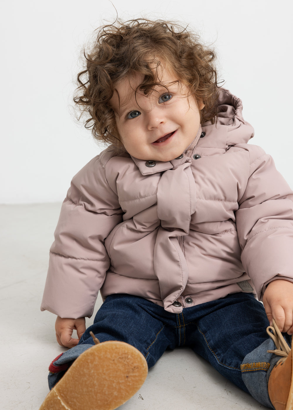 Let plum dunjakke til børn med hætte og lynlås, båret af model.