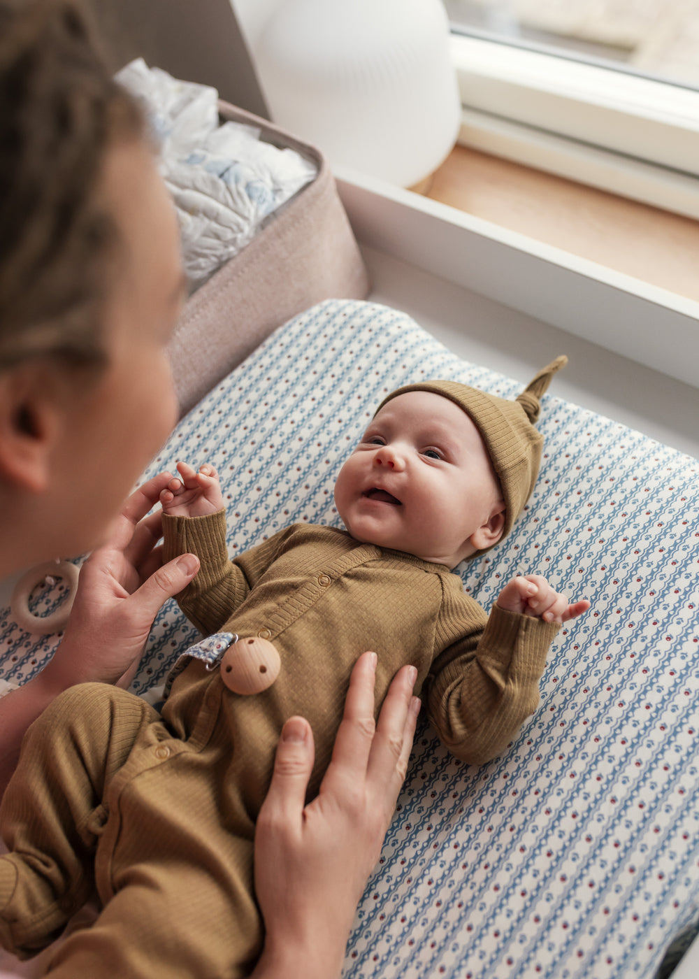 Baby i ribbstrikket brun holdragt til baby i blødt materiale med lange ærmer, lange ben, tryknapper og futter og brun babyhue