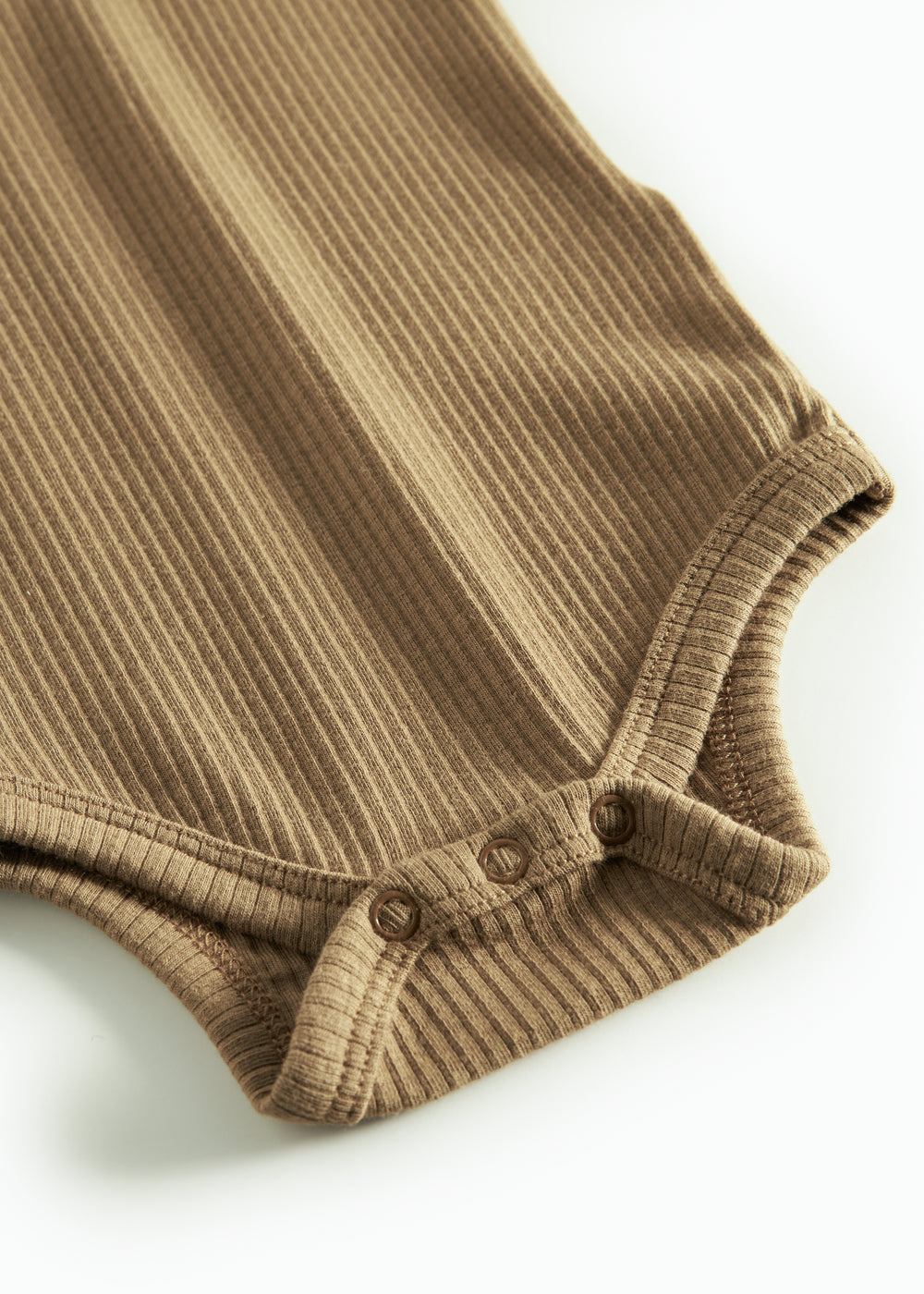 Brun strikket babybody med lange ærmer, stolpe knaplukning og trykknapper mellem benene.
