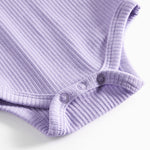 Lilla ribstrikket babybody med lange ærmer og knapper mellem benene