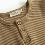 Detalje af brun ribstrikket langærmet t-shirt med knapper