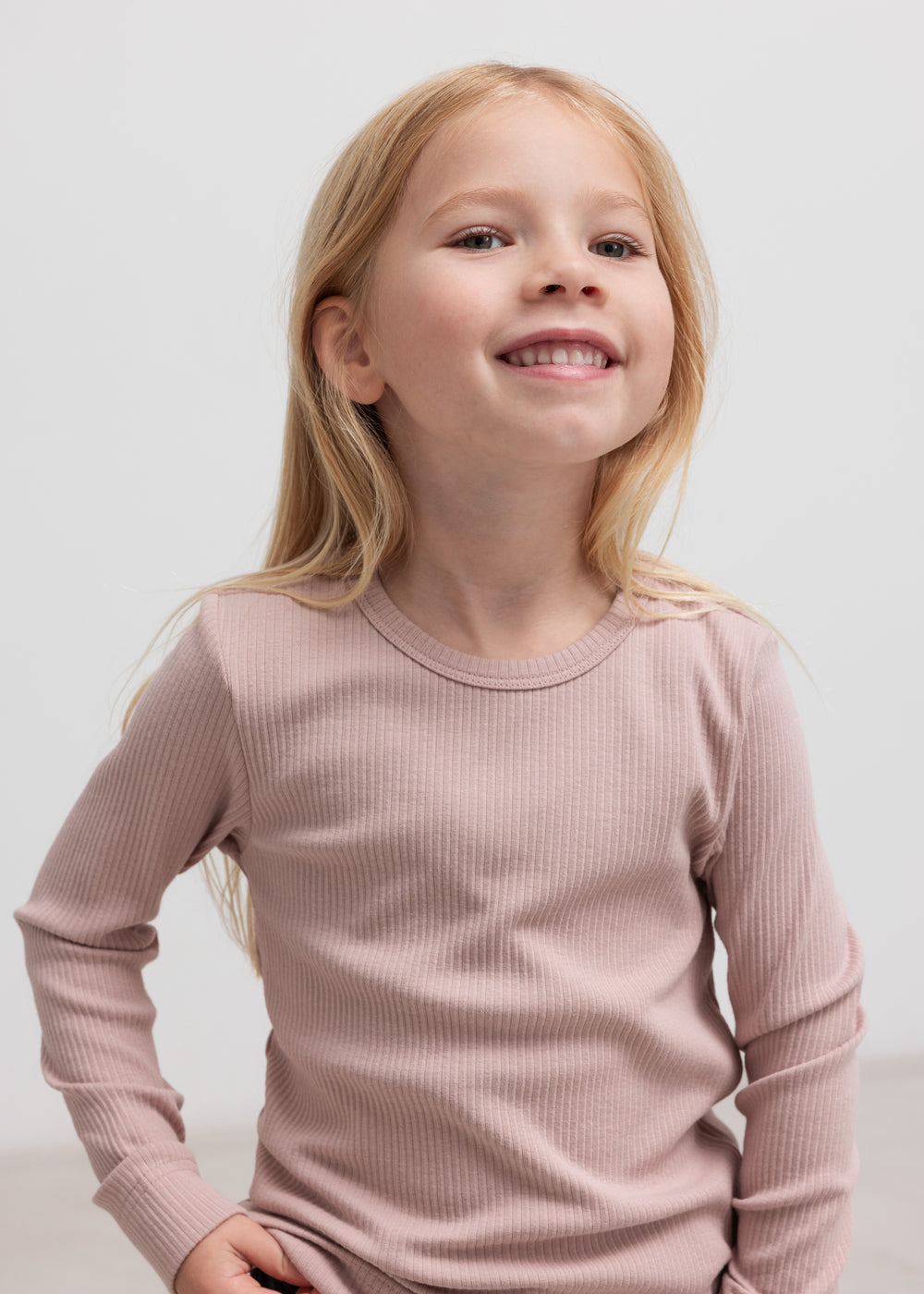 Bunke af foldede børne t-shirts i forskellige farver