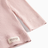 Detaljer af ribstrikket nederste kant på rosa børnetøj