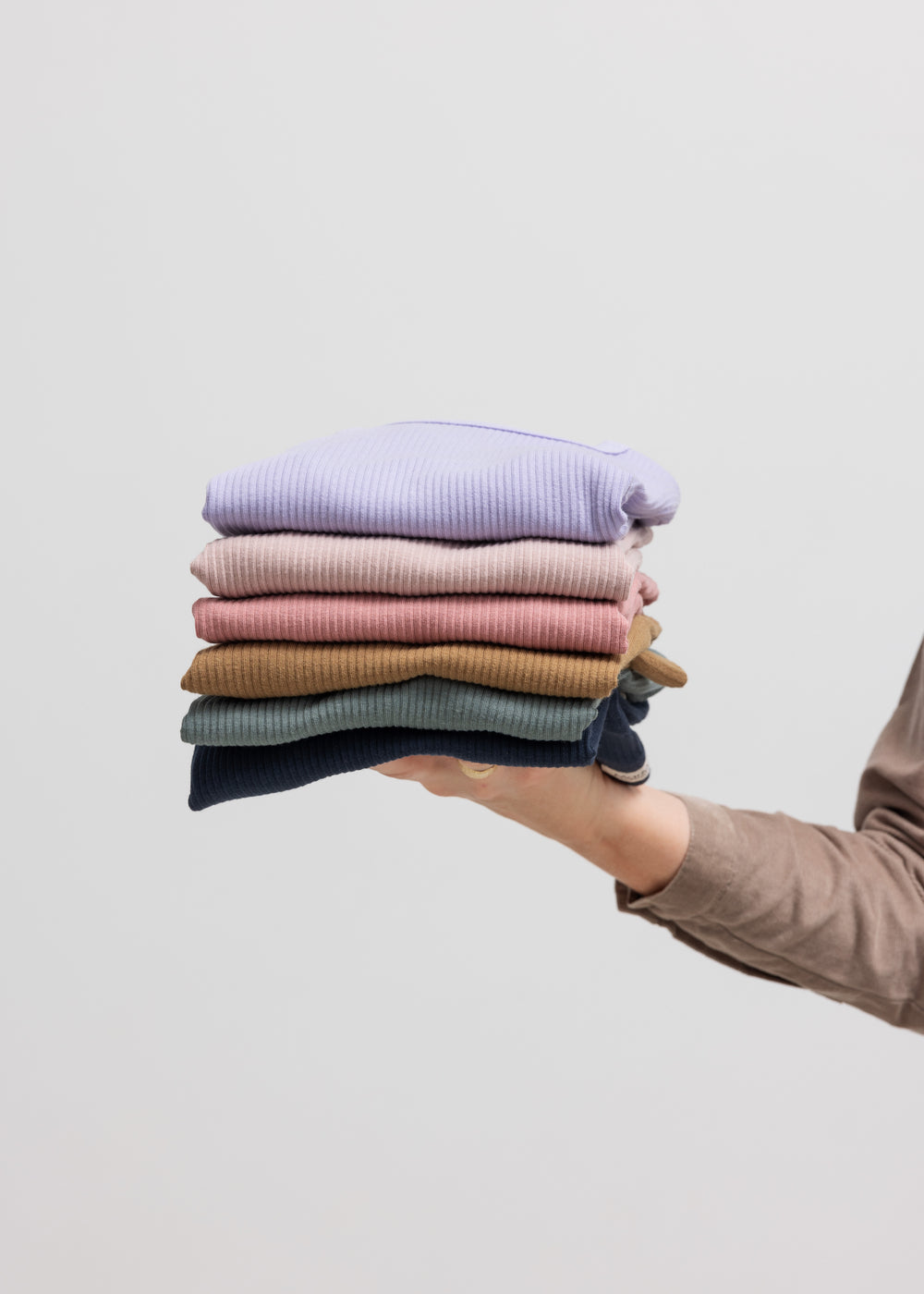 Bunke af foldede børne t-shirts i forskellige farver