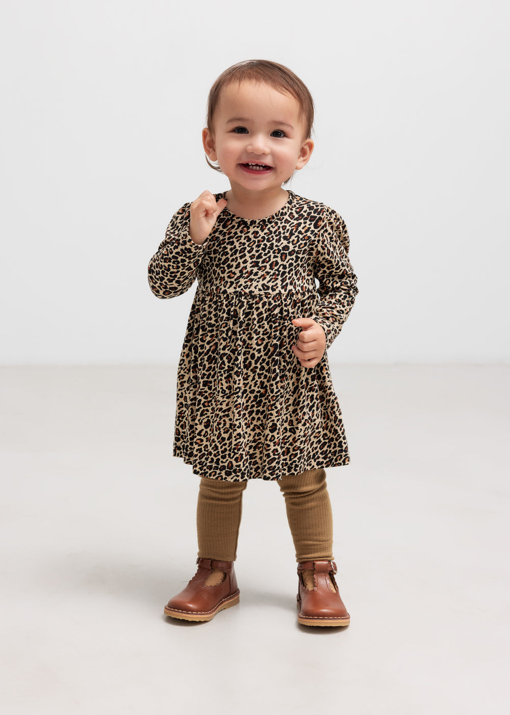 Barn i brun ribbet strikket kjole med leopardmønster og brune leggings