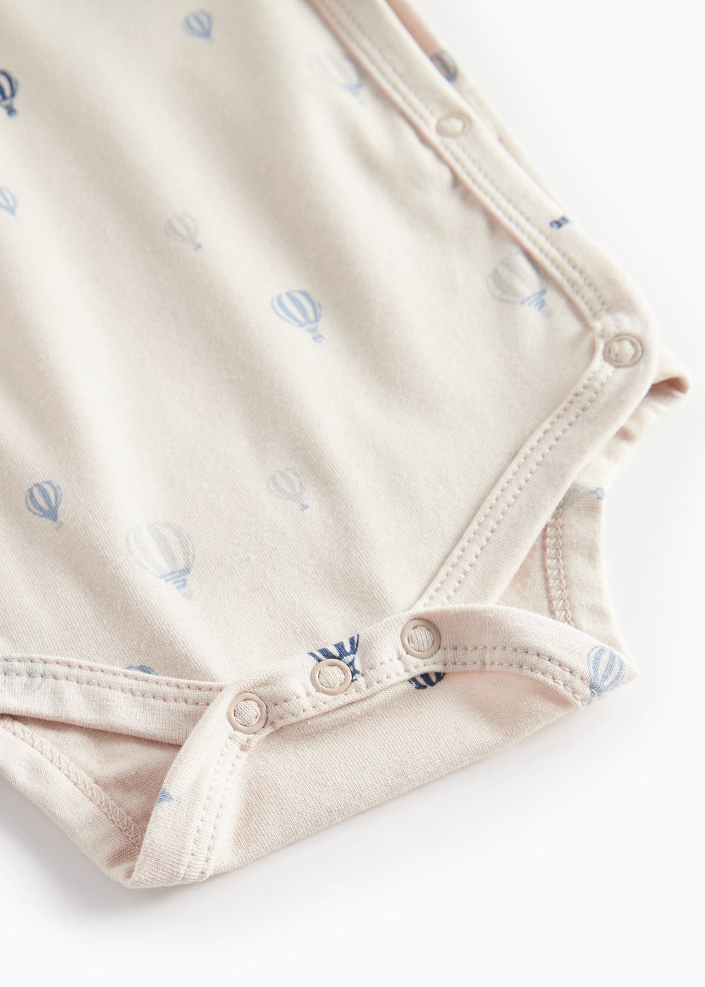 Beige bodystocking med blå luftballoner og knaplukning i skridtet