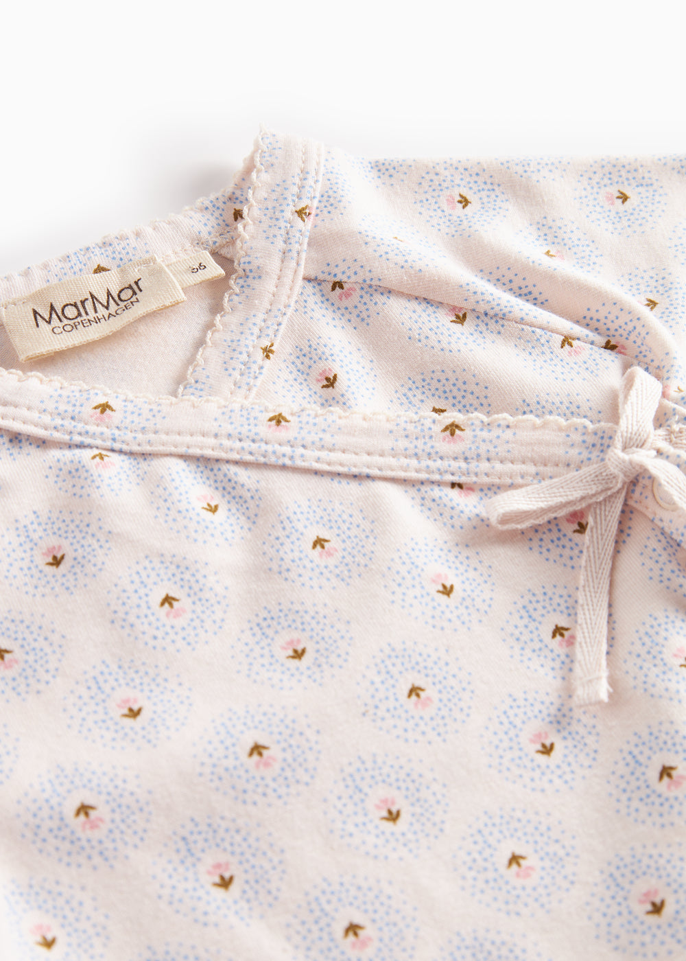 Babybluse med rund hals og knudedetalje ved skulderen, små tulipanmønstre