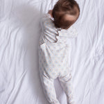 Heldragt til baby i hvid med små tulipanmønstre, båret på spædbarn