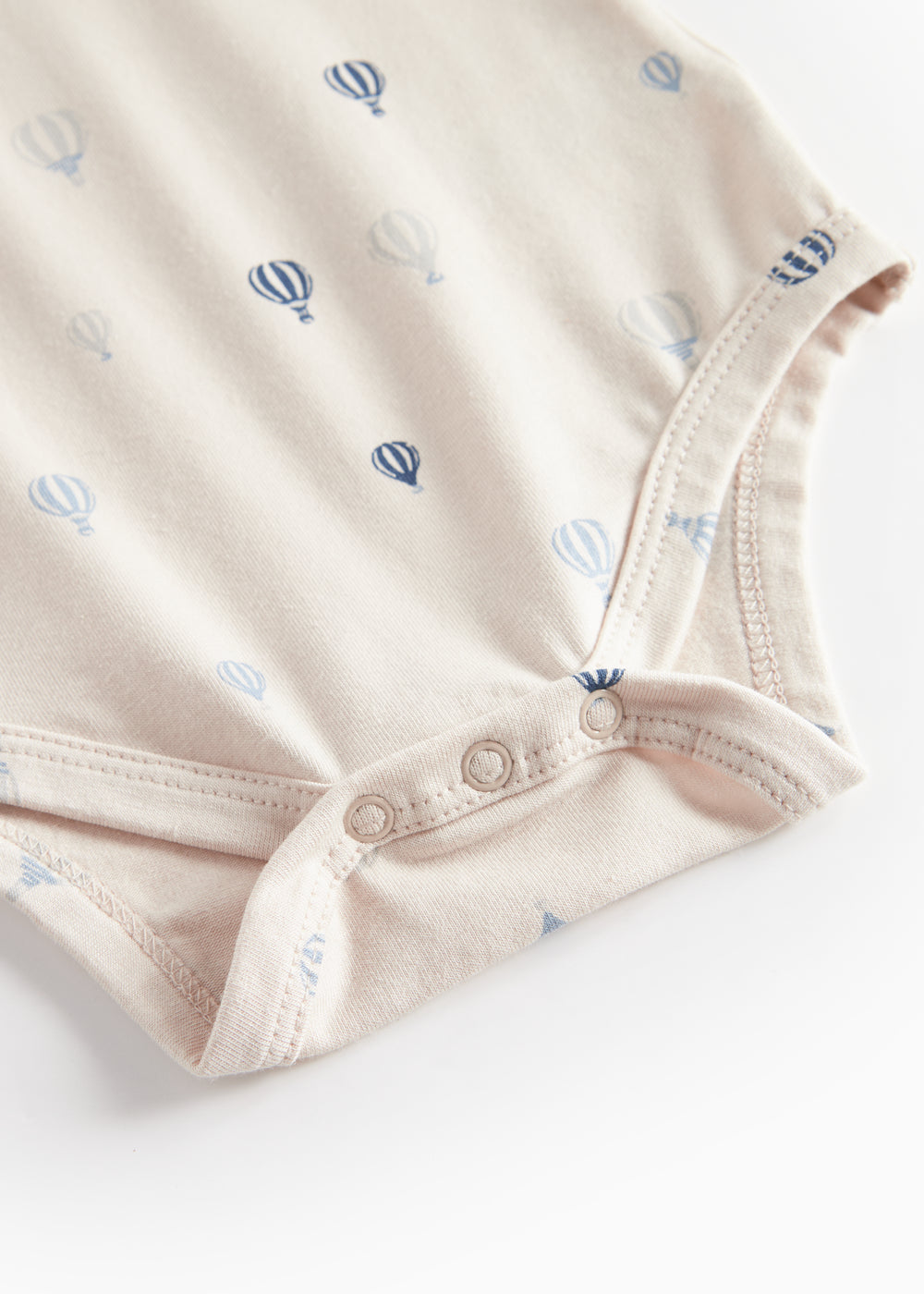 Beige bodystocking med blå luftballonprint og tryk-knaplukning ved skridtet.