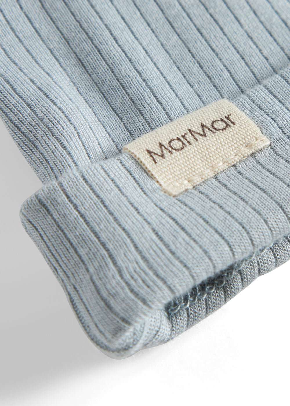 Lys blå babyhue med manchet og beige logoetiket