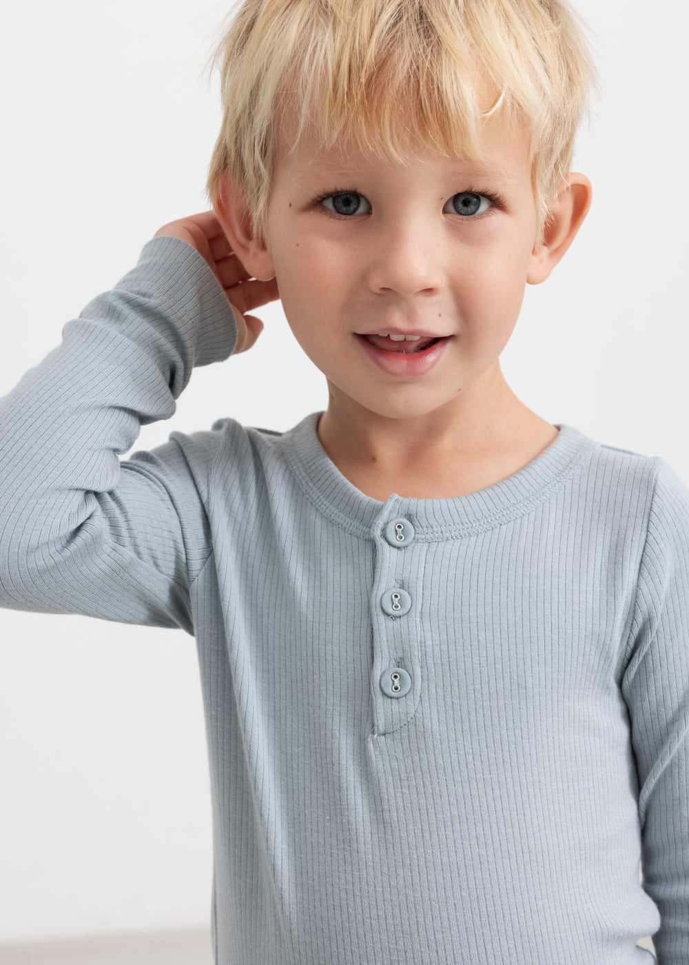 Lyseblå langærmet T-shirt med tre knapper foran, vist på barn