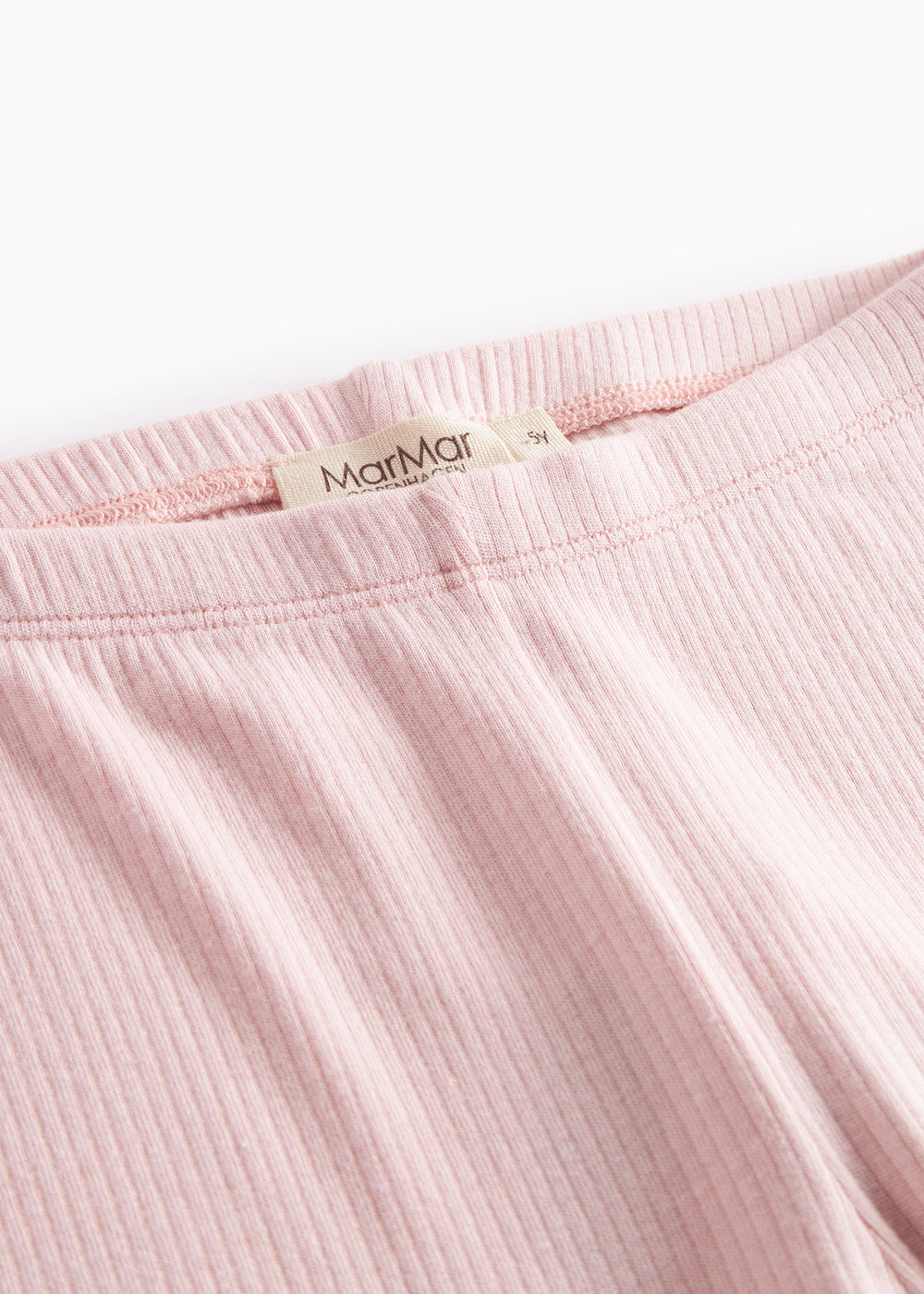 Lyserøde leggings, nærbillede af elastisk talje og mærke.