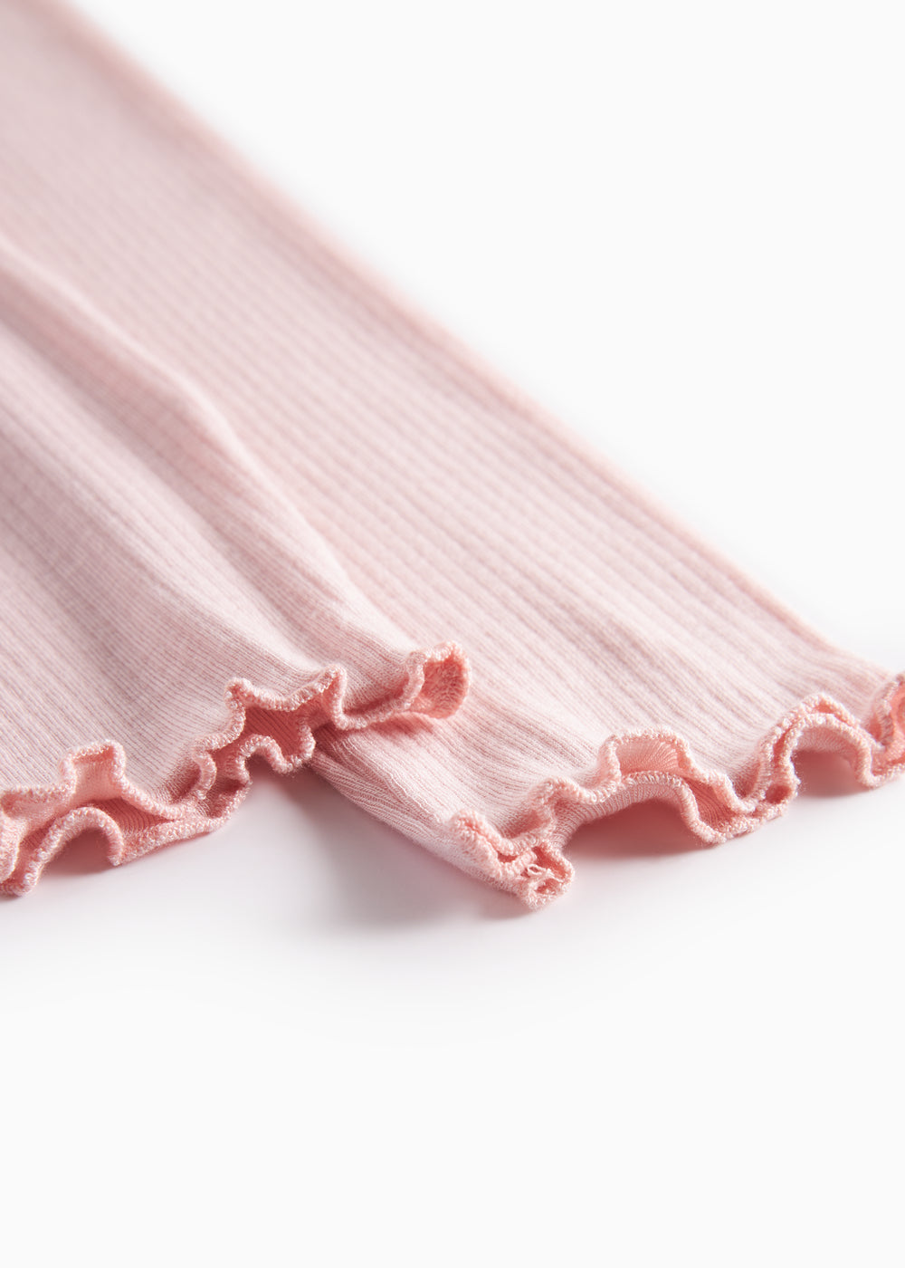 Lyserøde leggings med rynket kant ved benåbningen.