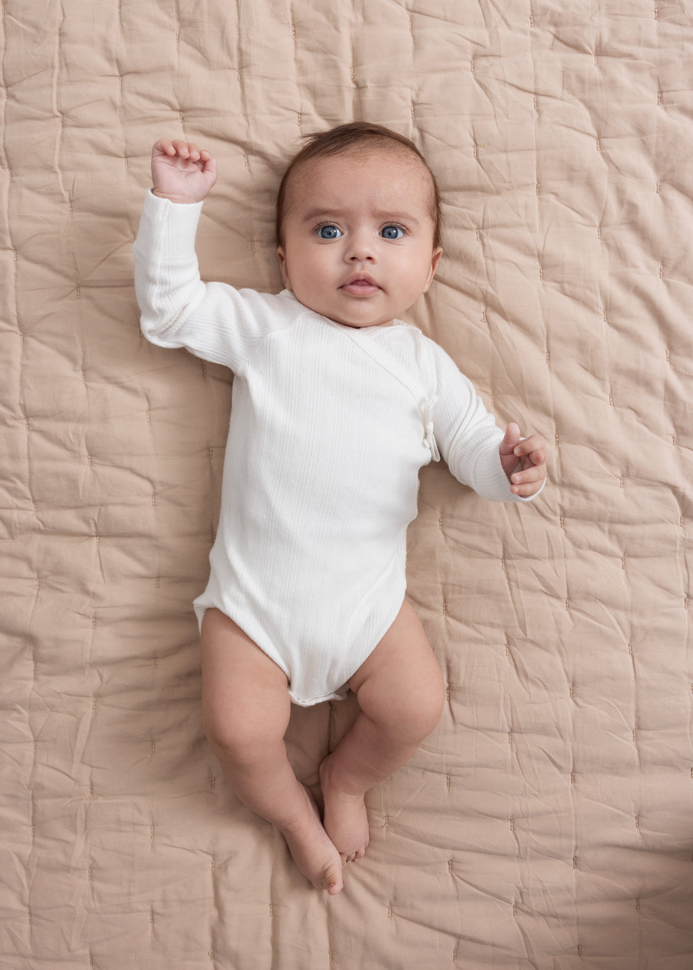 Baby quilt tæppe i beige med quiltmønster og synlig kant langs kanterne