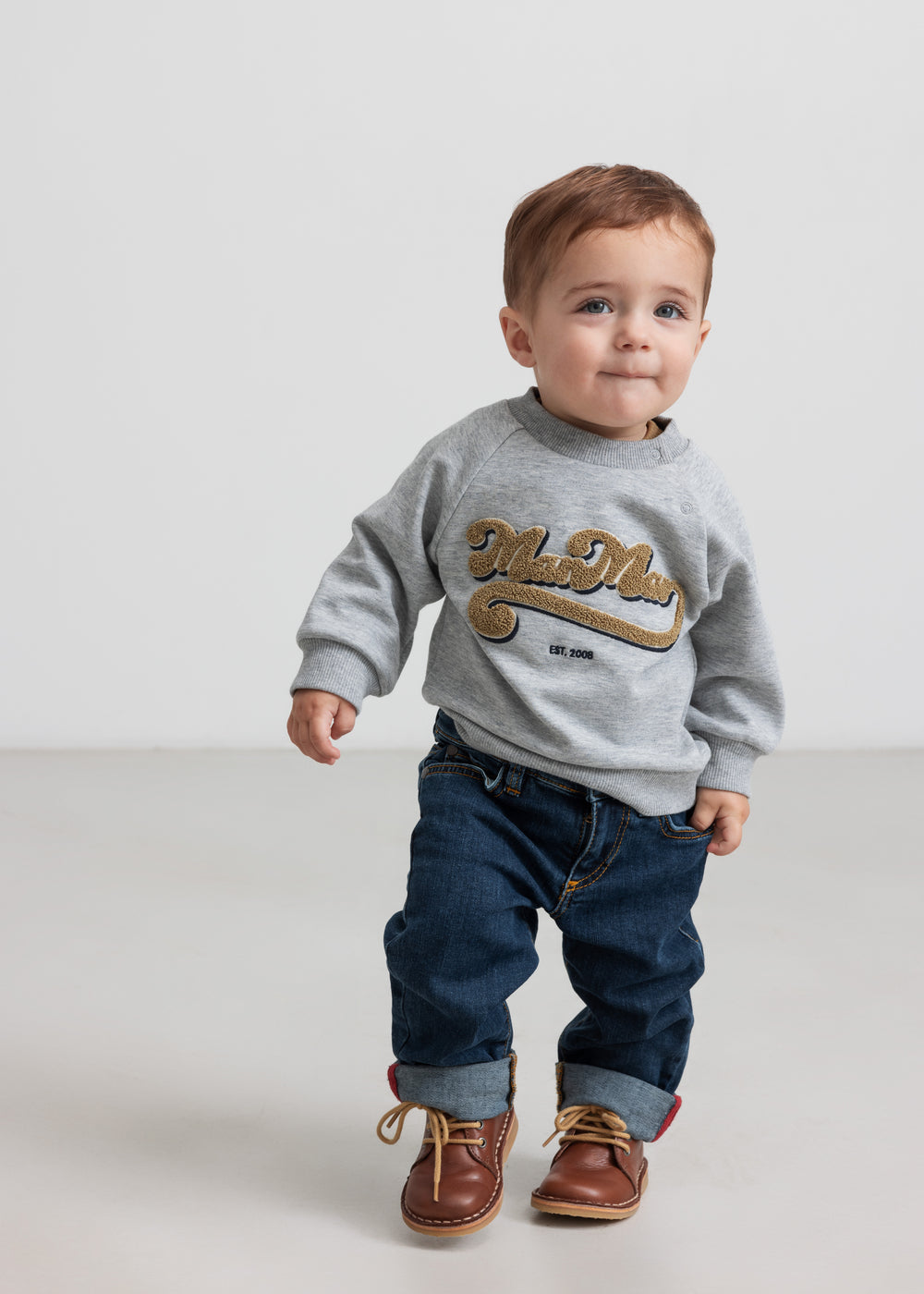Børn iført grå sweatshirt med guld broderi