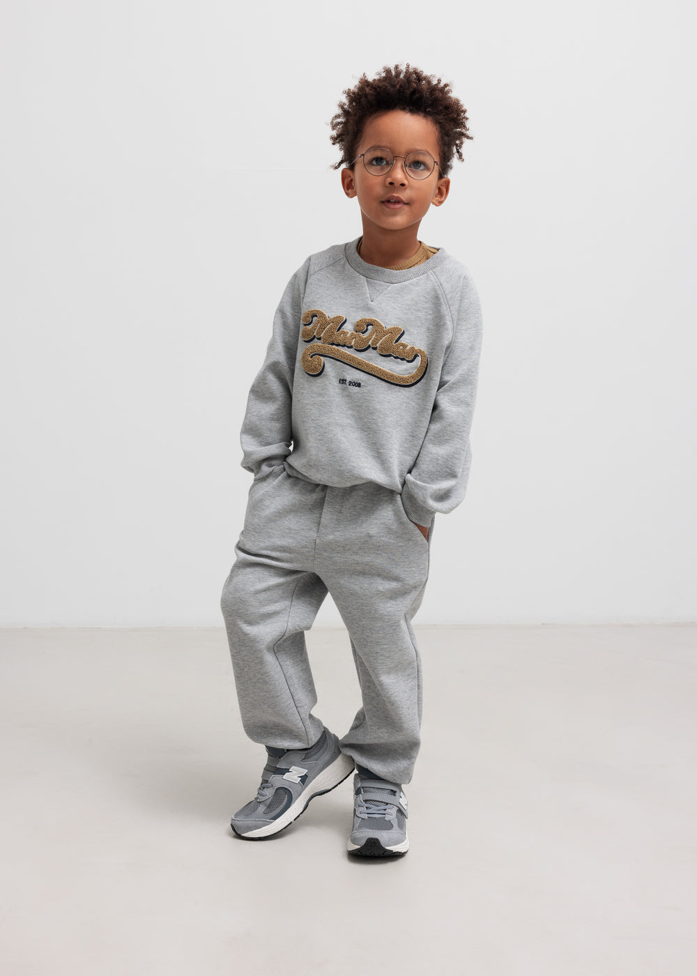 Børn iført grå sweatshirt og grå joggingbukser