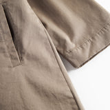 Detaljebillede af ærme og lommer på kaki chino frakke
