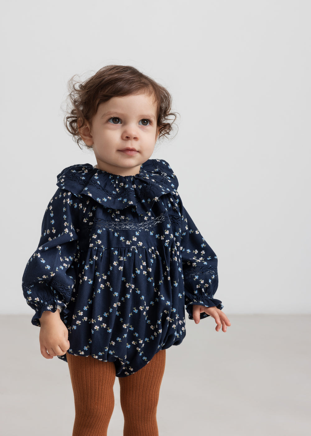 Baby iført mørkeblå blomstermønstret holdt