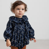Baby iført mørkeblå blomstermønstret holdt