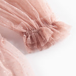 Detaljebillede af rosa tylkjole med elastisk manchet og volanger