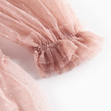 Detaljebillede af rosa tylkjole med elastisk manchet og volanger
