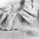 Detaljer af flæsekrave på grå strikbluse med hulmønster