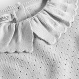 Detaljer af flæsekrave på grå strikbluse med hulmønster