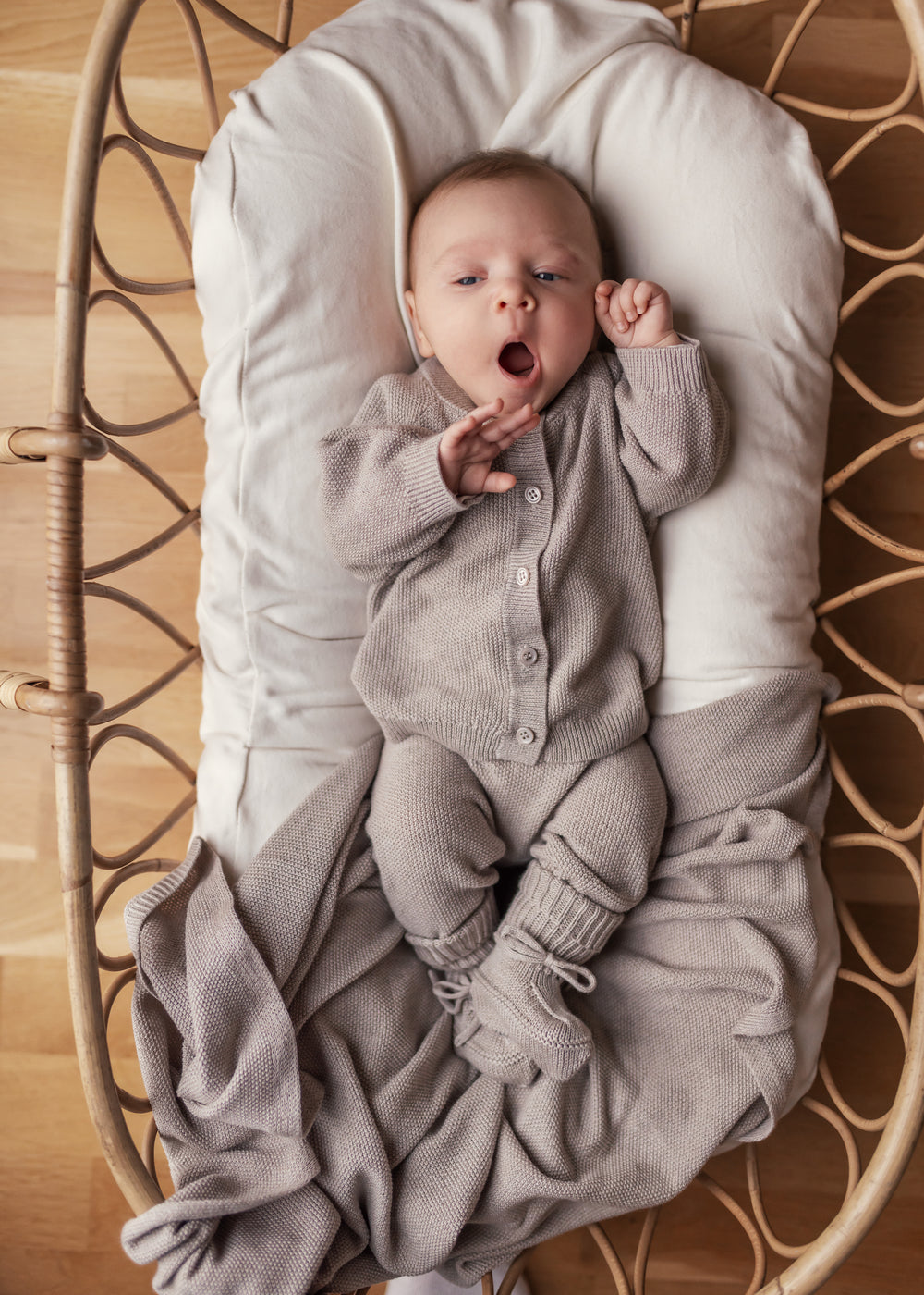 Barn med beige strikket babytæppe
