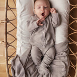 Barn med beige strikket babytæppe