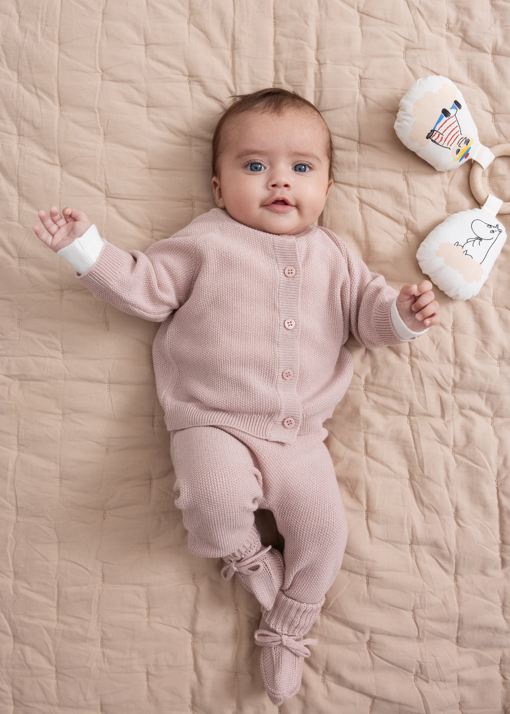 Baby iført lyserød strik babytøj