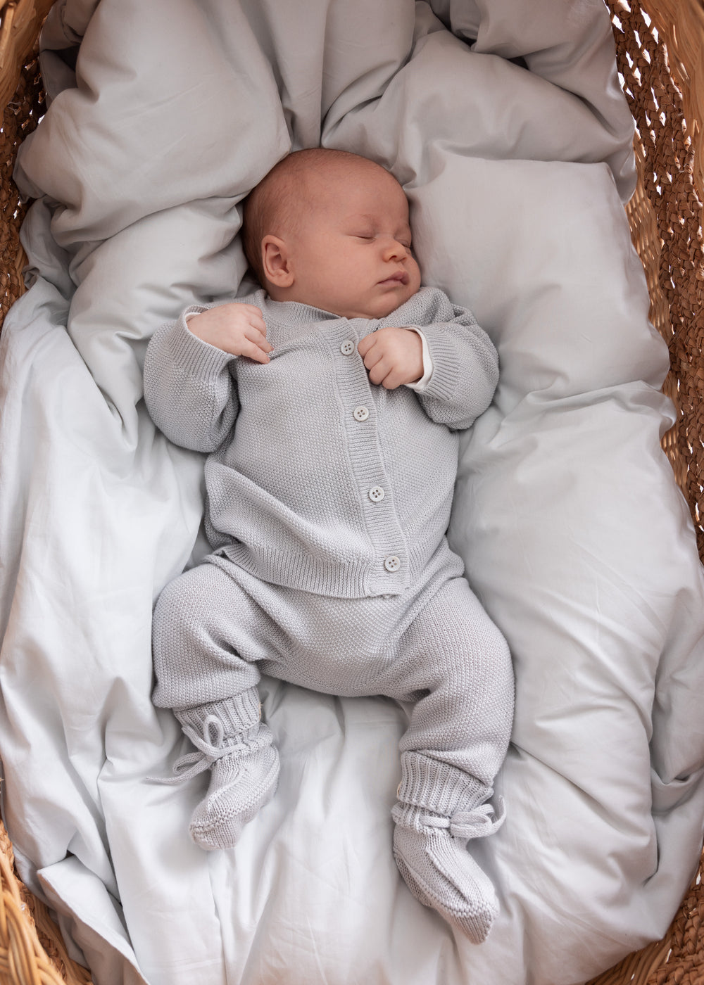 Baby solgt i blødt, gråt strikket babyoutfit