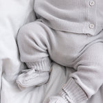 Detaljer af babyben i gråt strikket sæt med små strømper