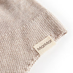 Detaljer af beige strikket babyhue med MarMar mærke