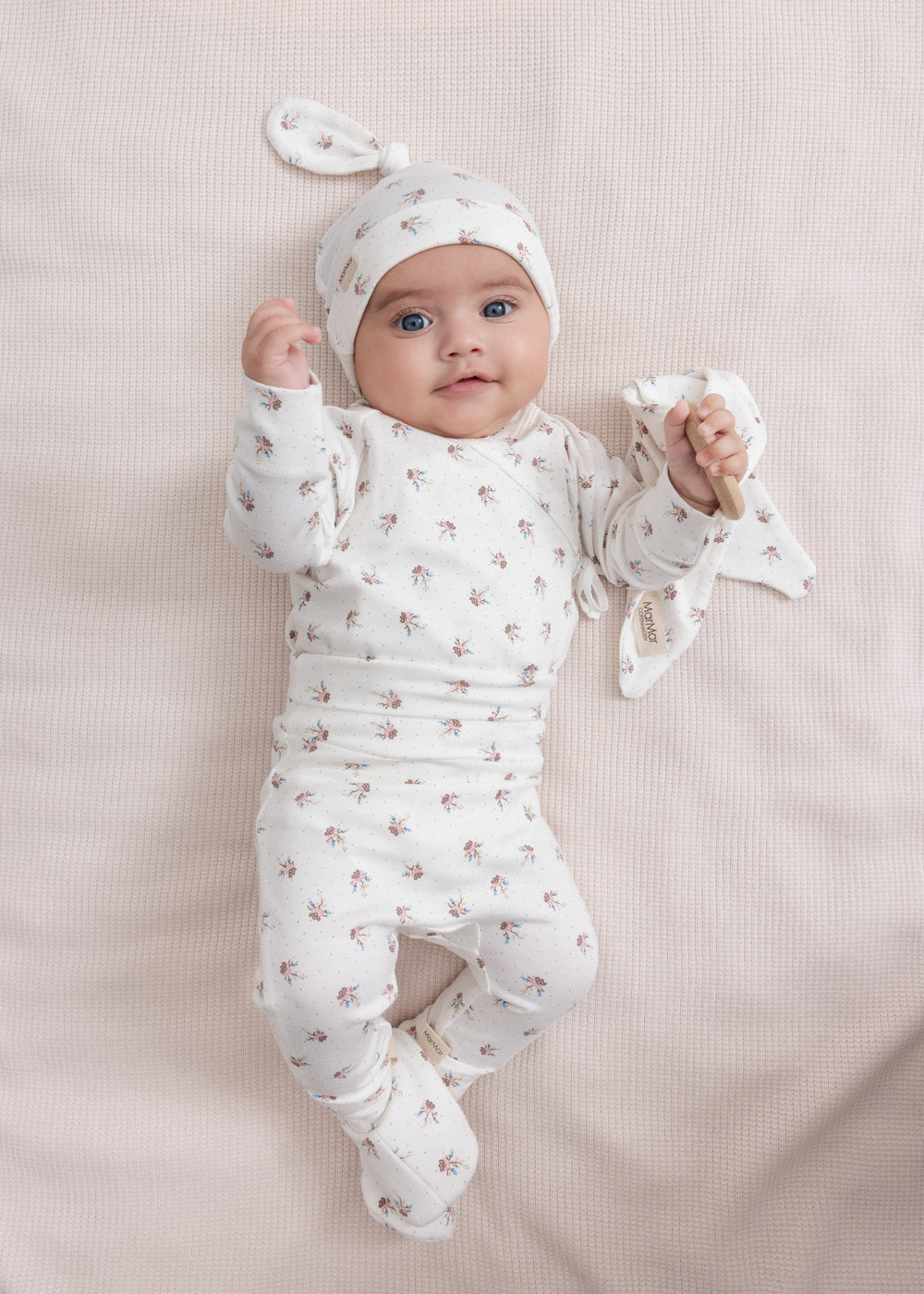 Baby iført mønstret hat og blød dragt