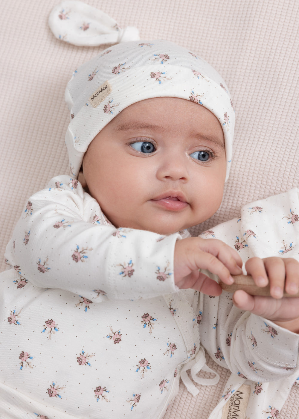 Baby iført mønstret hat og blød dragt
