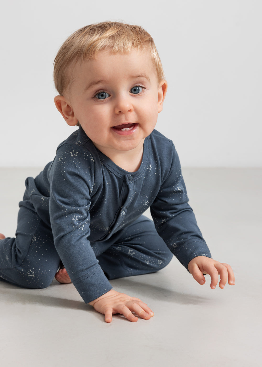 Baby iført mørkeblå heldragt med stjerneprint