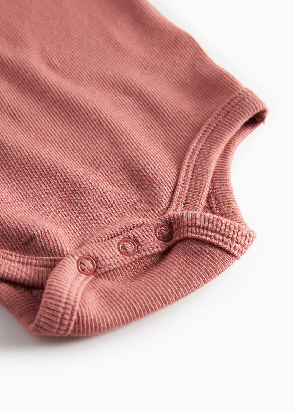 Støvet rosa ribstrikket body med lange ærmer til baby